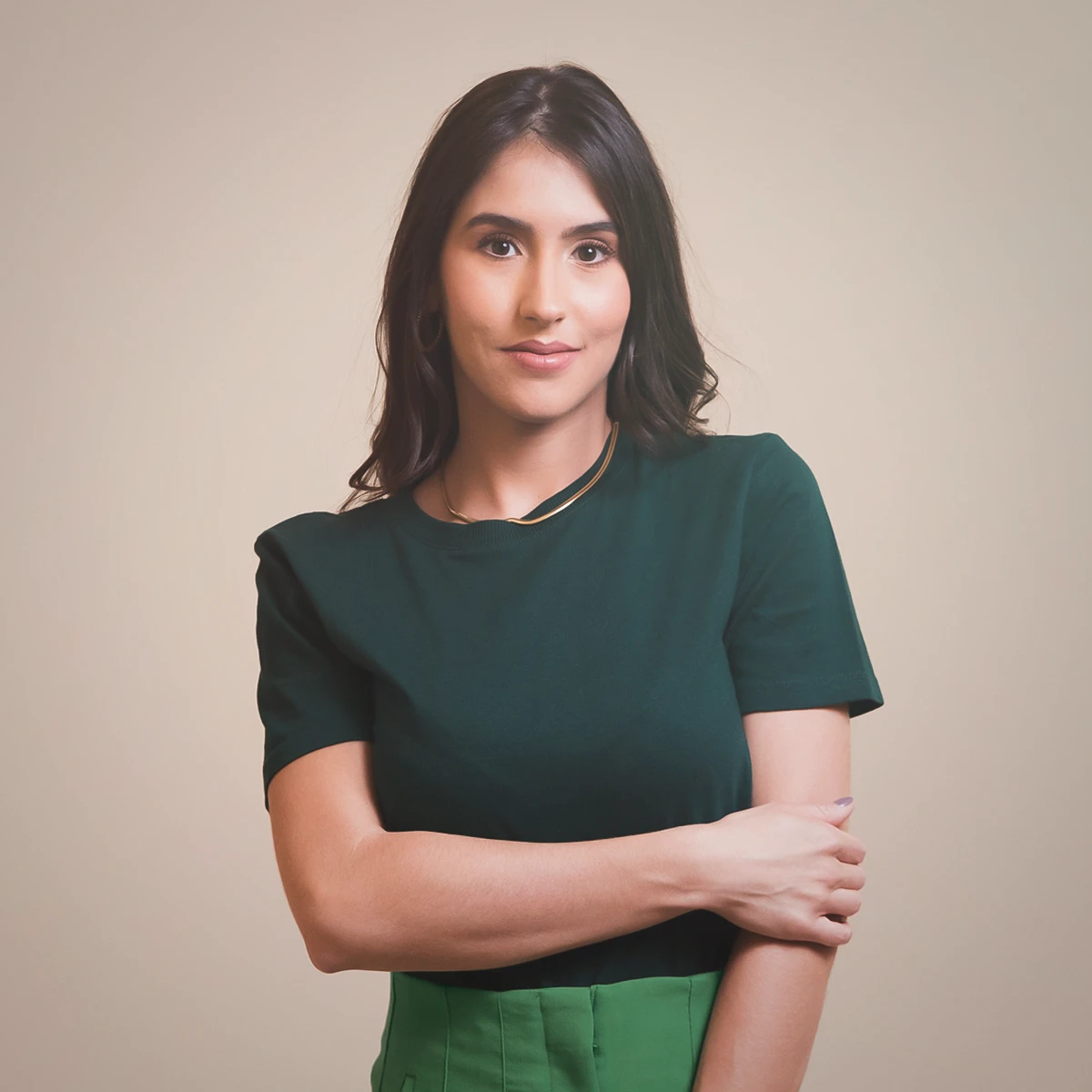Marina Giraldin, de camiseta verde e braços cruzados